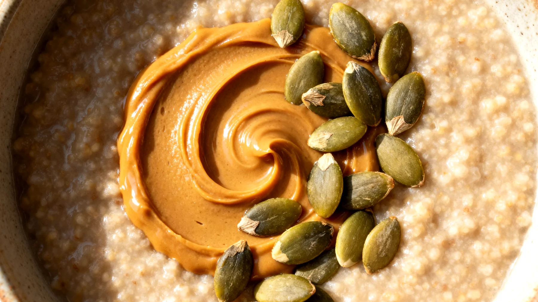 Amaranth-Porridge mit Mandelmus und Kürbiskernen"